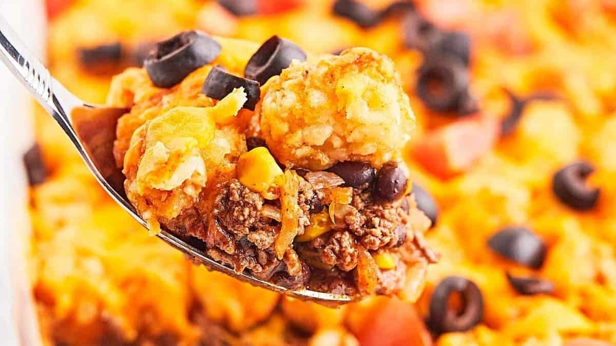 A shared spoonful of Mexican casserole with black beans and black olives, perfect for comfort food recipes.