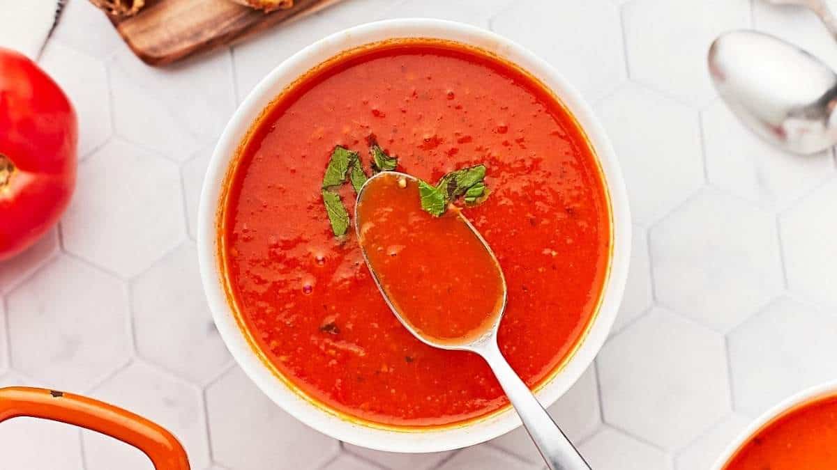 A delicious tomato soup served in a bowl with a spoon.