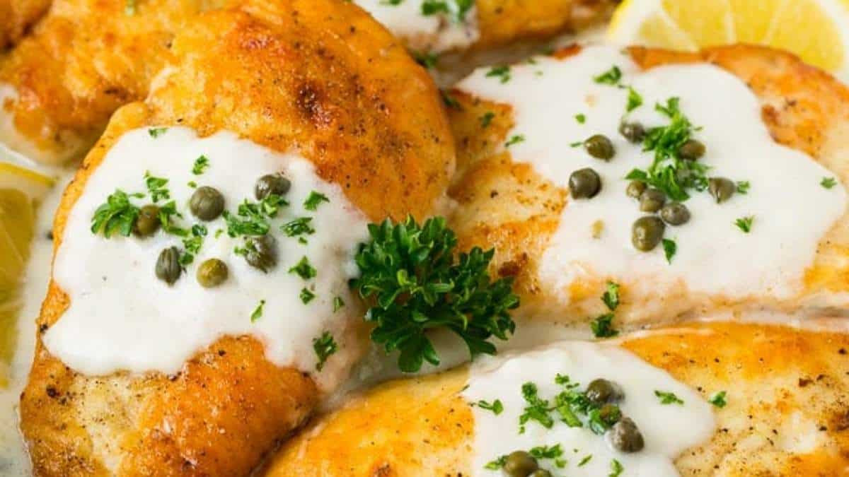 Chicken breasts with lemon sauce and capers on a plate.