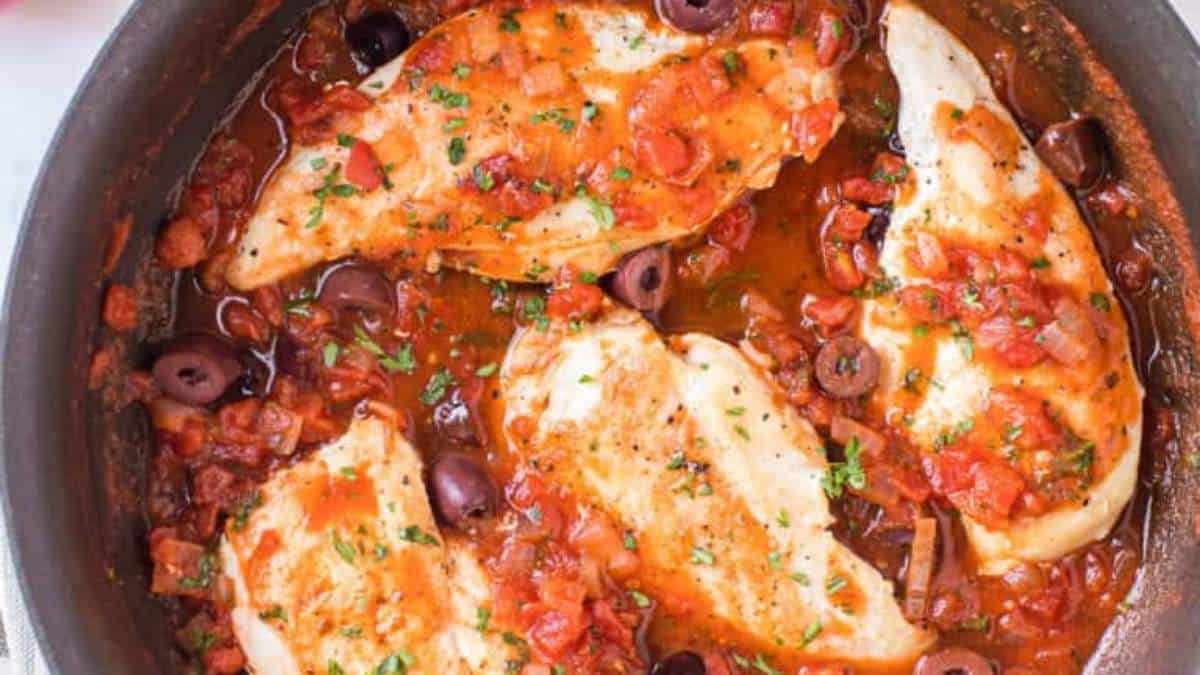 Chicken in tomato sauce in a skillet.