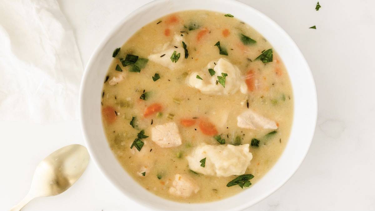 Easy chicken dumpling soup in a white bowl.
