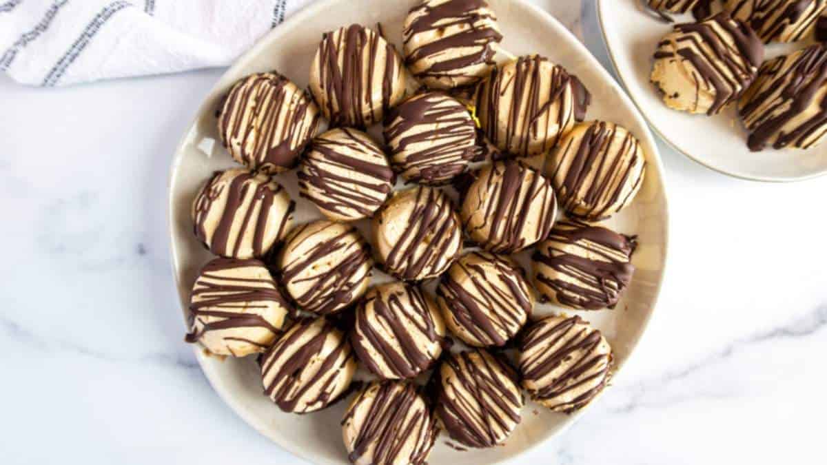 No Bake Peanut Butter Cookies on a white plate with chocolate drizzle.
