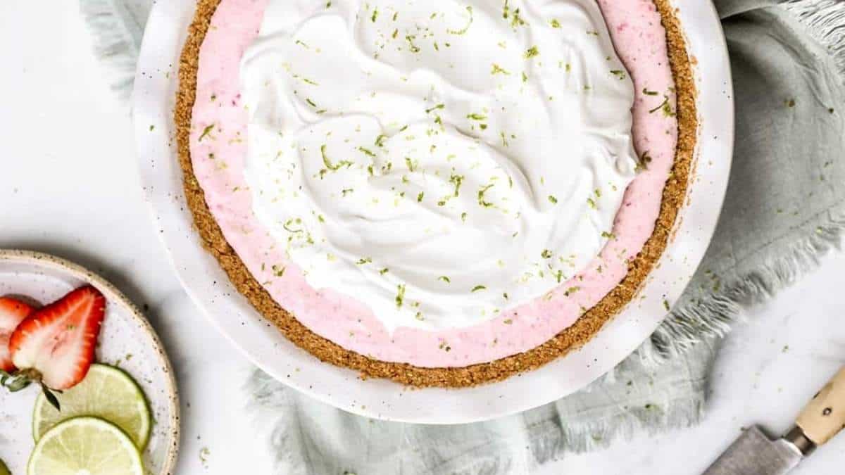 A shared strawberry pie with whipped cream and strawberries.