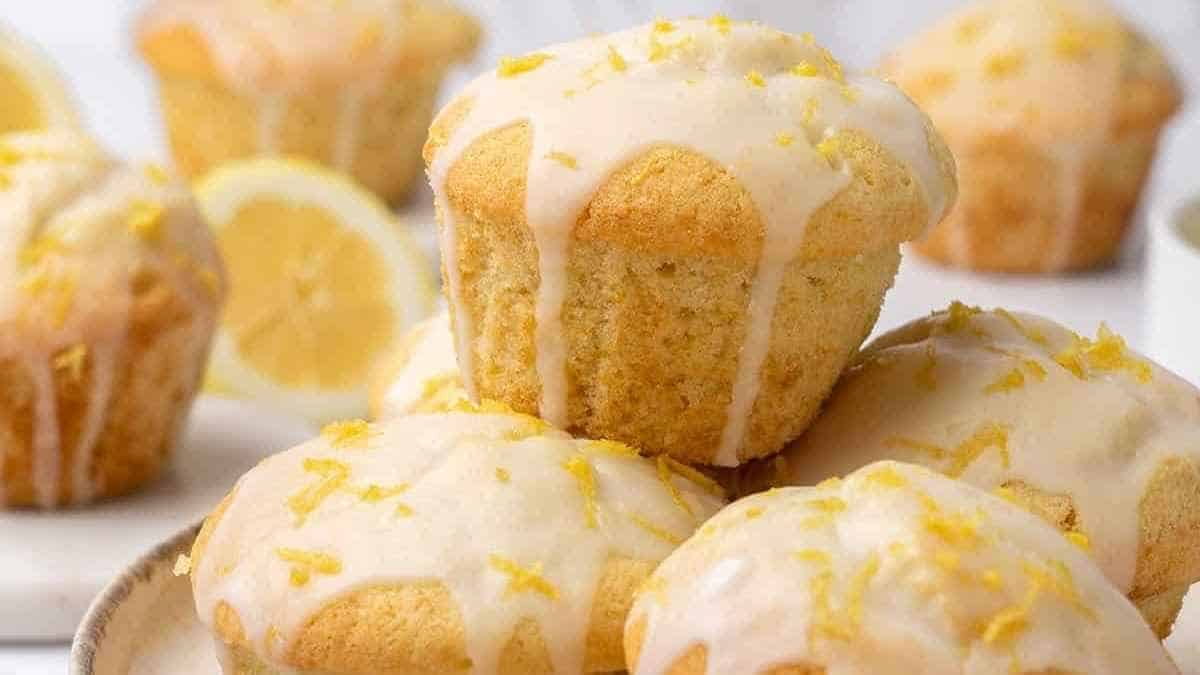 A stack of lemon muffins with icing on a plate. Delicious Recipes for Muffins.