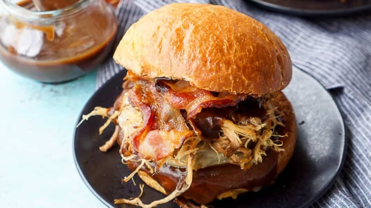 Bbq pulled pork sliders with a side dish of coleslaw on a black plate.