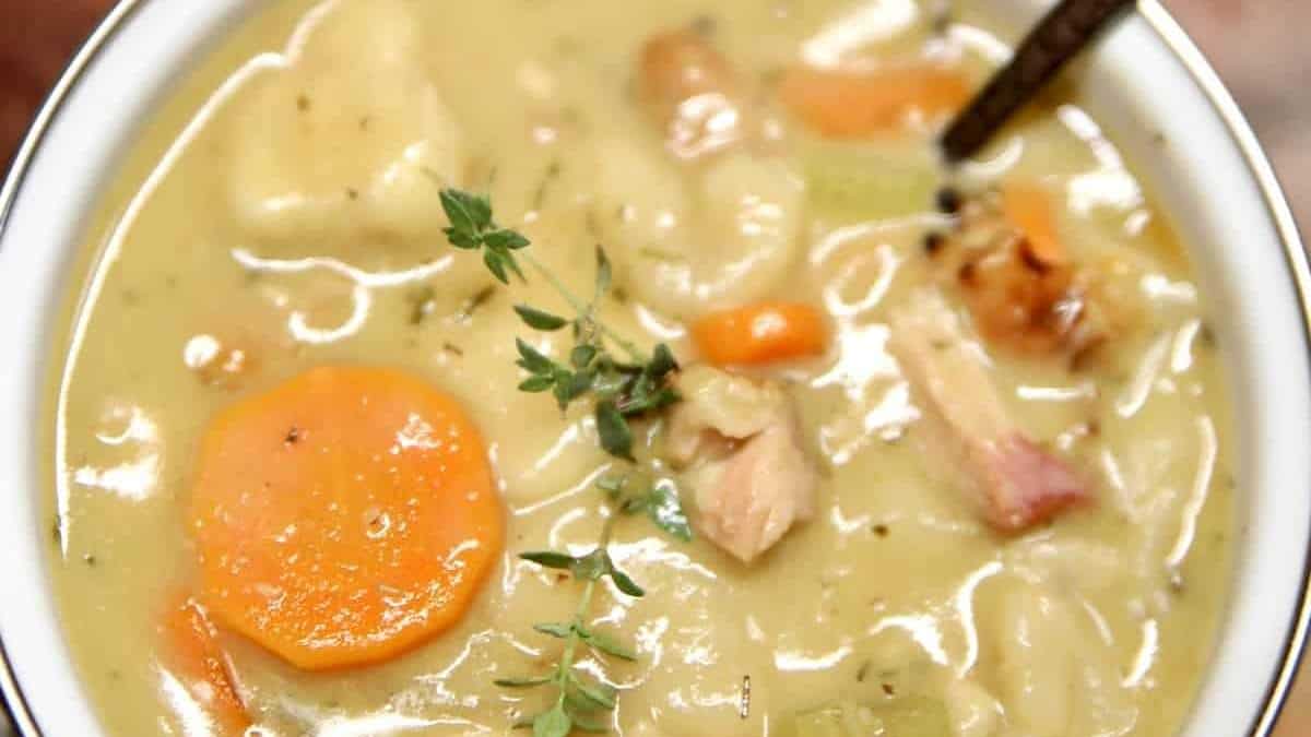 A comforting bowl of chicken noodle soup with carrots and a hint of thyme.
