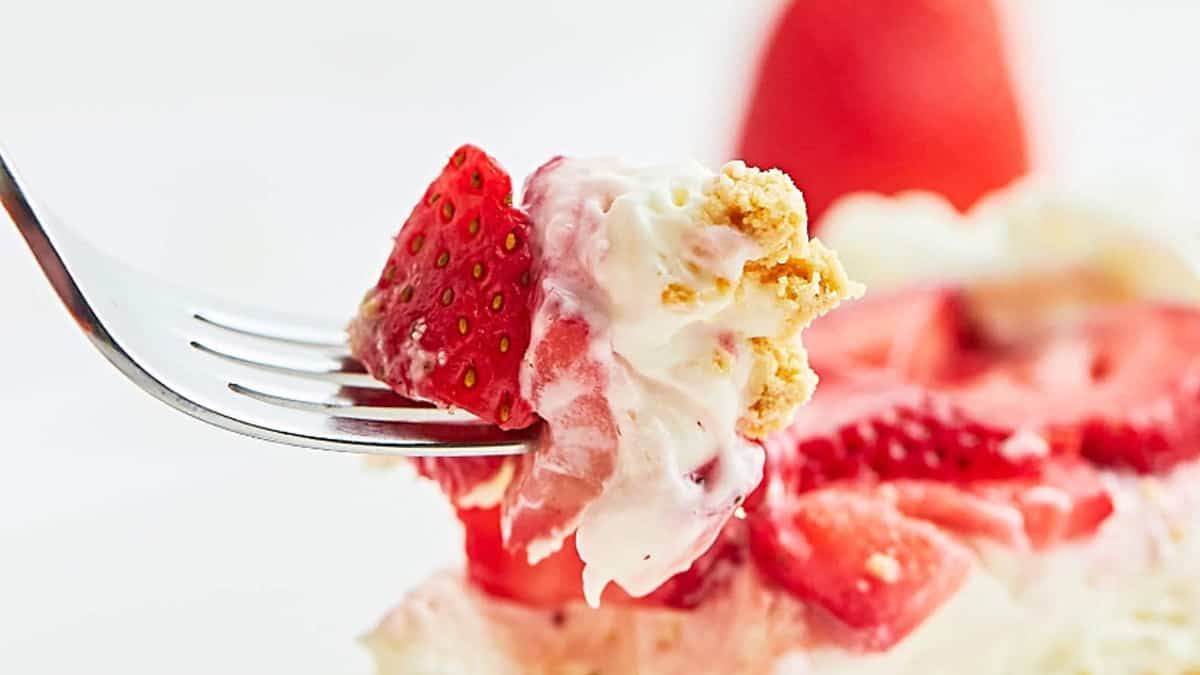 A bite of strawberry pie on a fork.