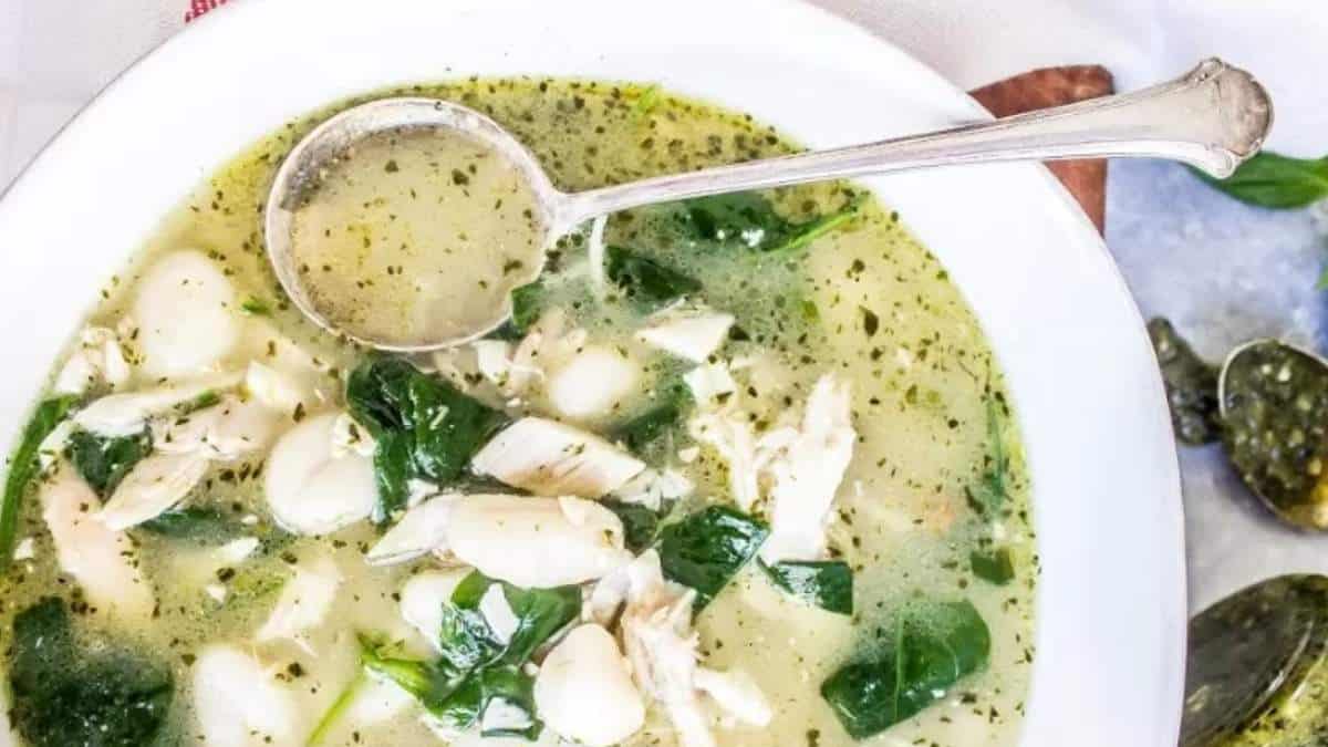 A delicious bowl of chicken and spinach soup garnished with a spoon. This nutritious soup recipe is sure to satisfy your taste buds.