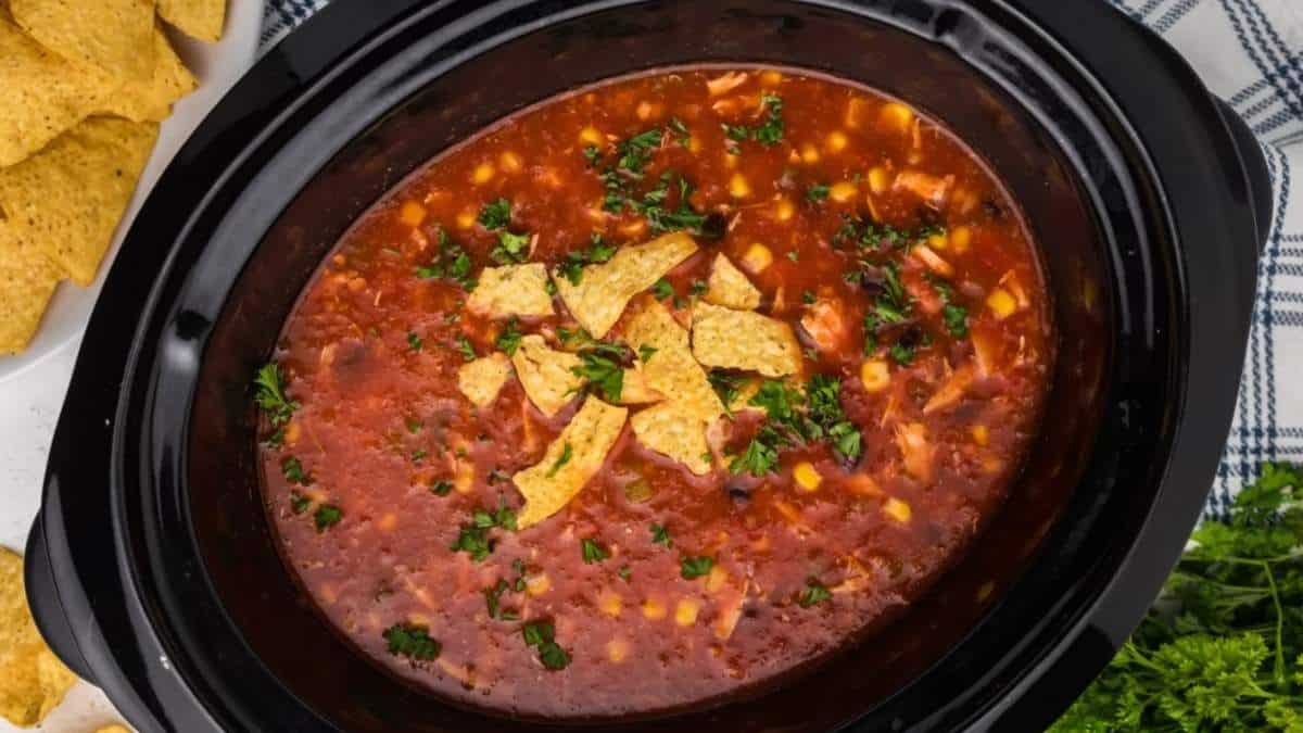 A crock pot full of Mexican chili and tortilla chips, perfect for soup recipes.