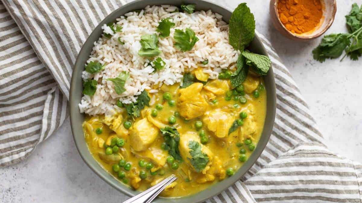 A comforting bowl of chicken curry with rice and peas, perfect for sharing.