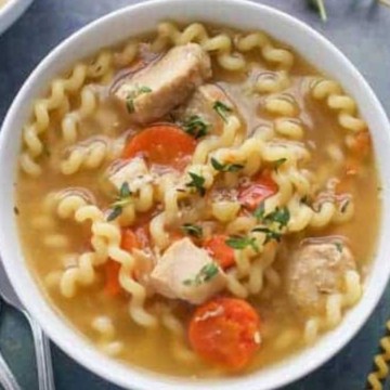A comforting bowl of chicken noodle soup featuring tender noodles and savory carrots.