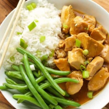 A white bowl with chicken, green beans and rice.