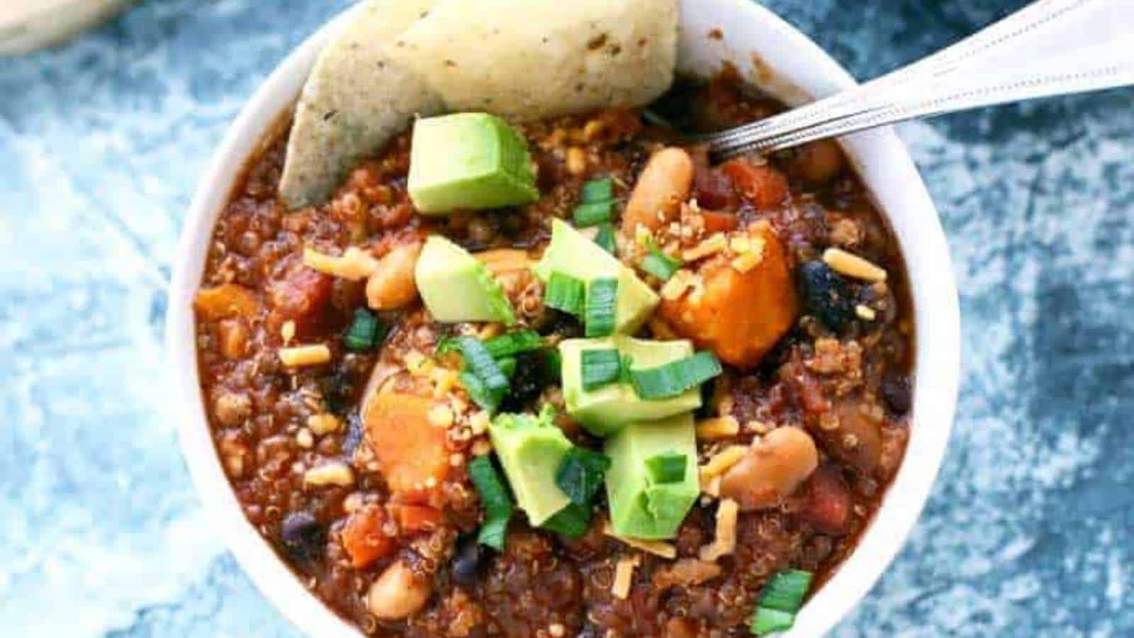 Chili in a bowl with avocado and tortilla chips.