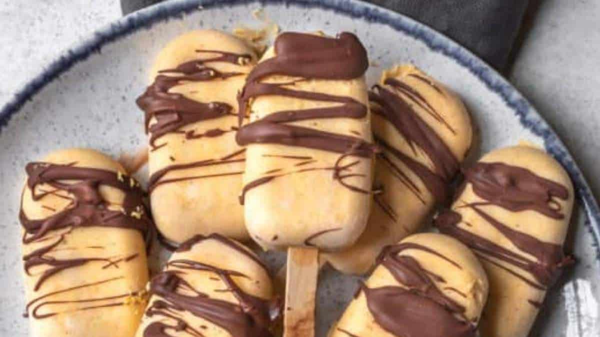 A shared round up of no bake desserts featuring chocolate covered popsicles on a plate.