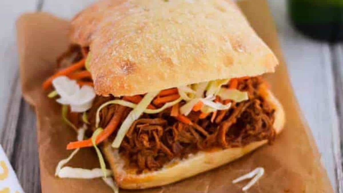 A shared comfort food favorite, the pulled pork sandwich is perfectly paired with tangy coleslaw and a refreshing bottle of beer to round up the ultimate meal.