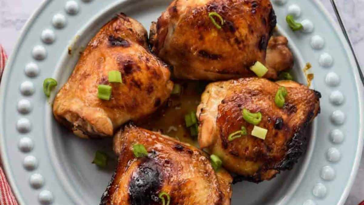 Grilled chicken on a plate with green onions.