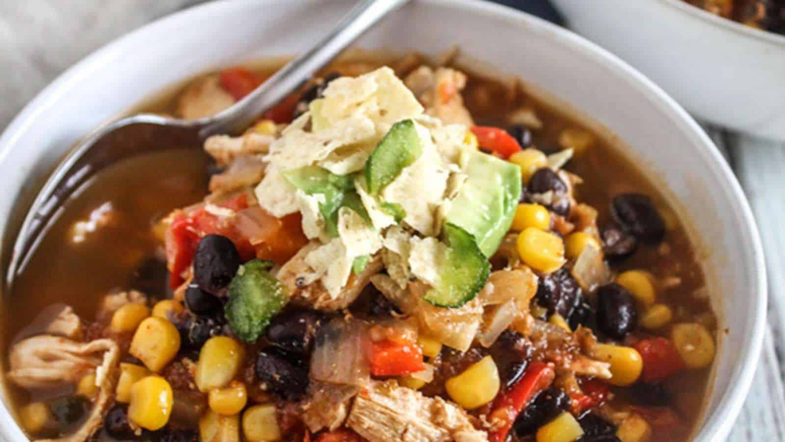 A bowl of mexican chicken soup with black beans and corn.