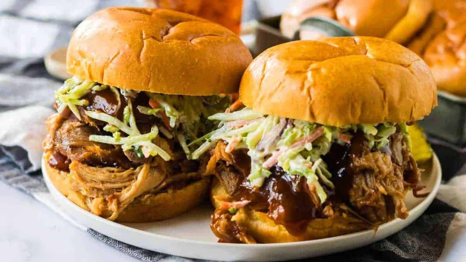 Two pulled pork sliders on a plate with coleslaw.