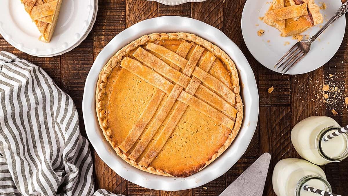 A slice of pumpkin pie on a wooden table, perfect for those who enjoy sweet pie recipes.