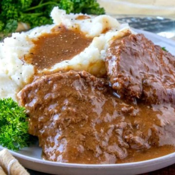 Meatloaf with gravy and mashed potatoes on a plate.
