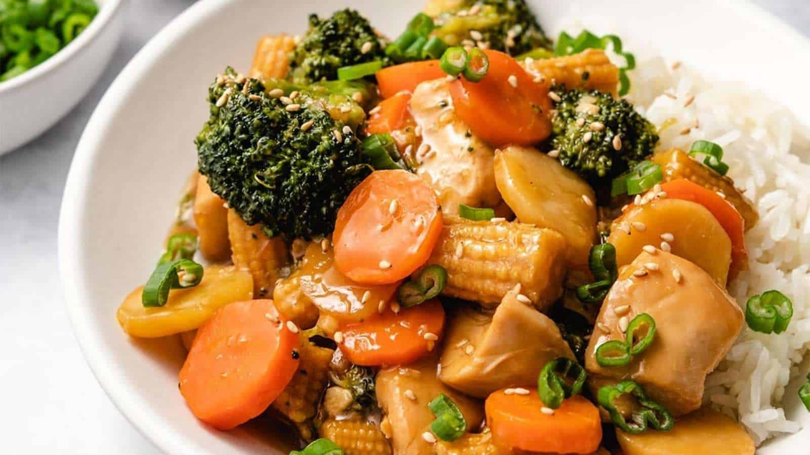 A bowl of asian stir fry with broccoli and carrots.