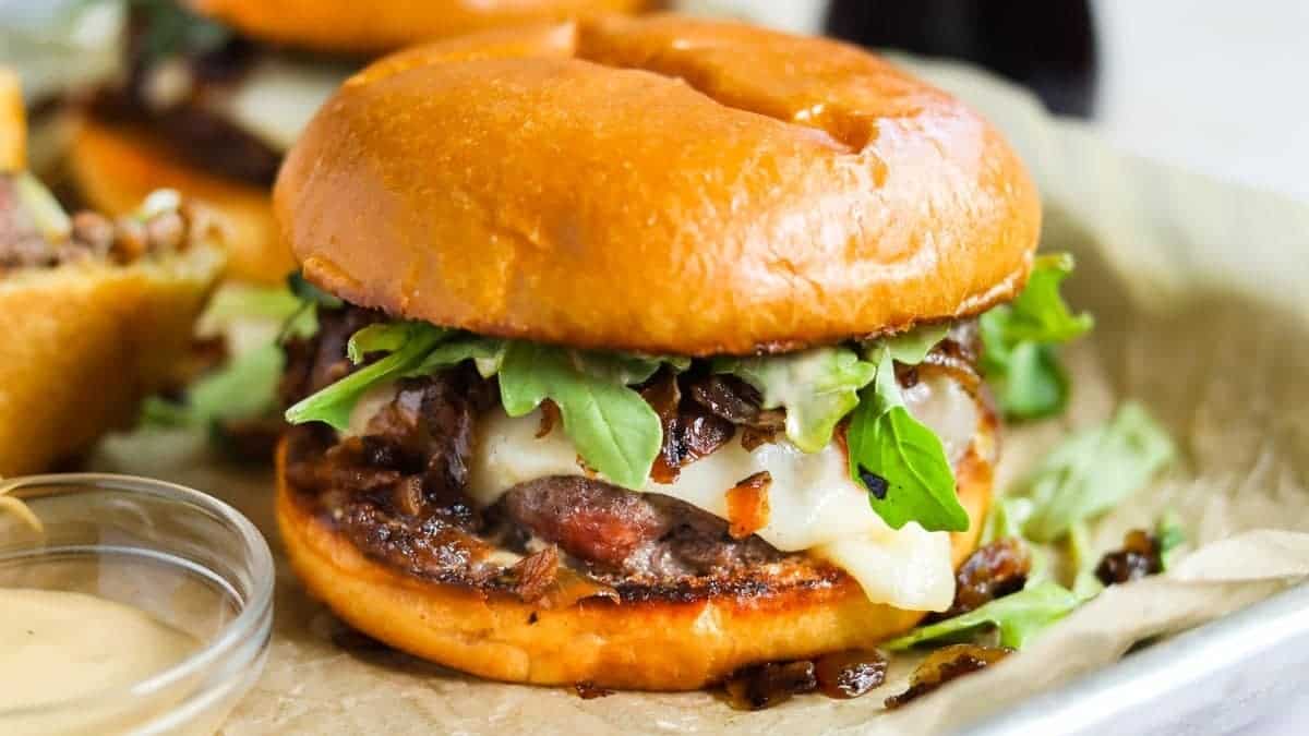 A burger with arugula and ketchup on a tray, served with side dishes.