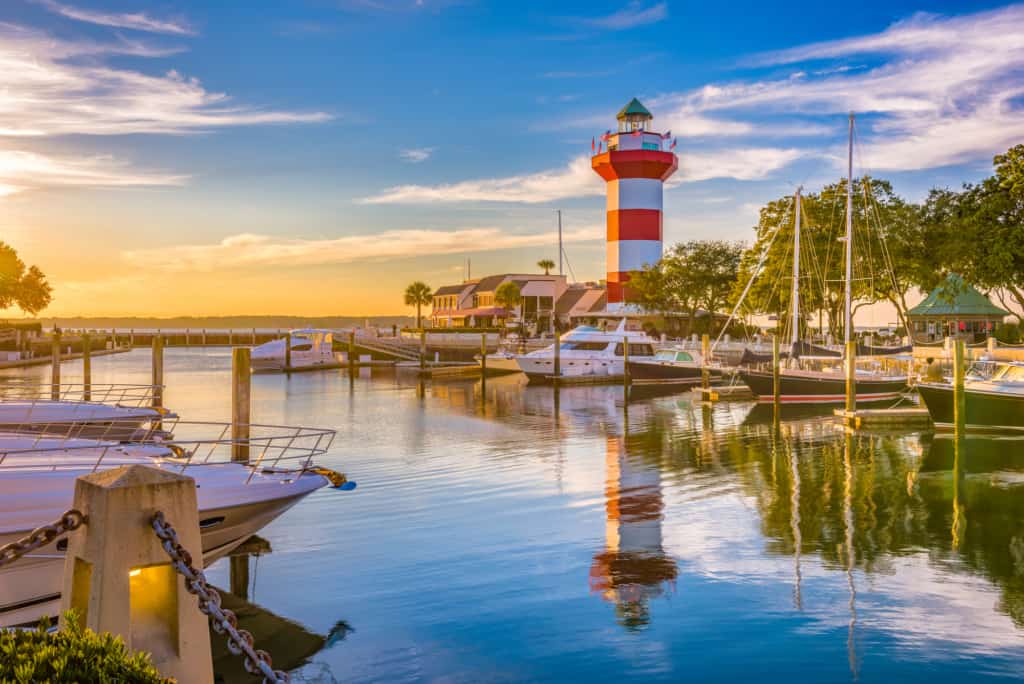 A boat docked at a scenic lighthouse surrounded by picturesque South Carolina beaches perfect for families.
