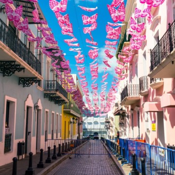 Pink butterflies hanging from the ceiling of a street in San Juan, Puerto Rico create one of the best things to do in Old San Juan.