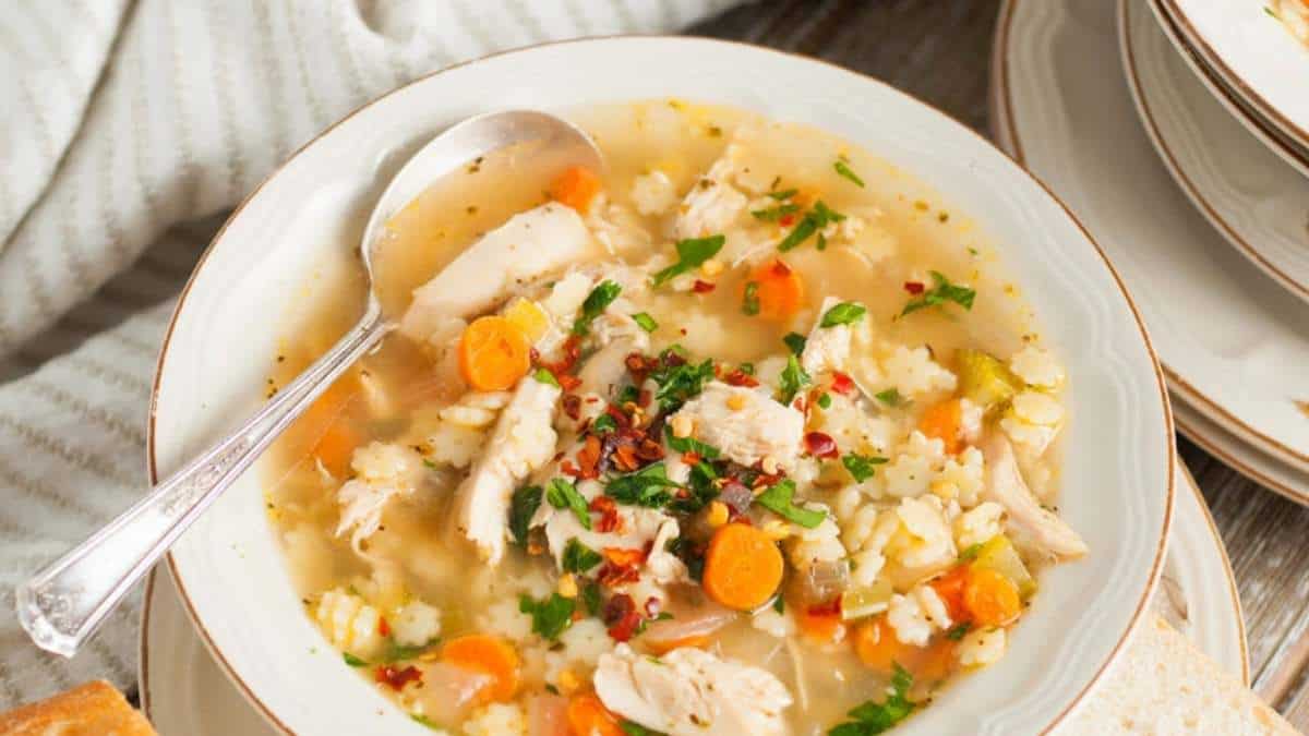 A delicious chicken noodle soup recipe with carrots and bread.