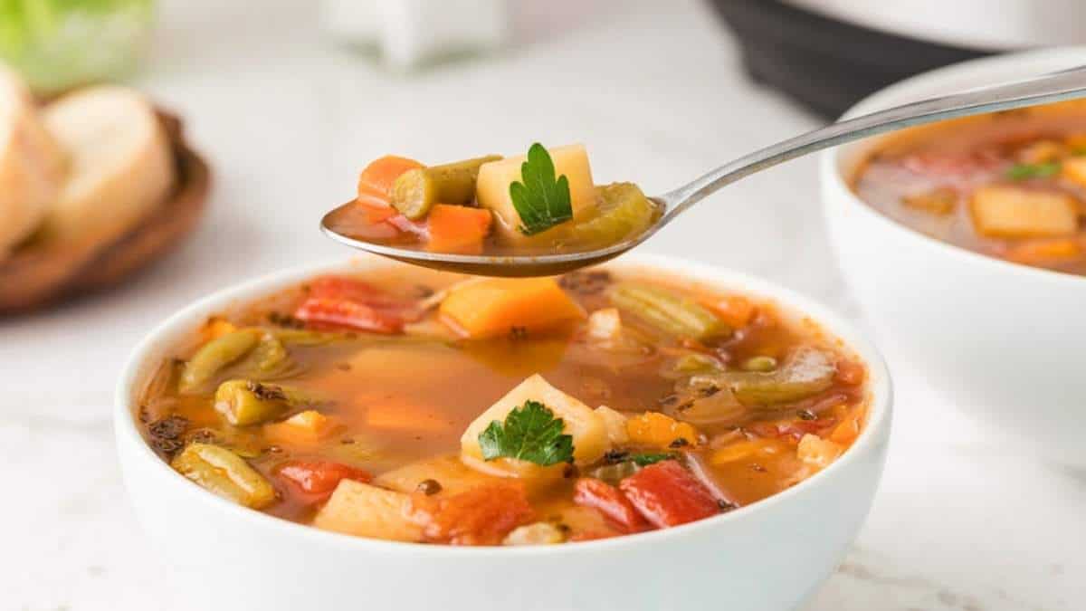 Two bowls of vegetable soup with a spoon, perfect for those seeking soup recipes.