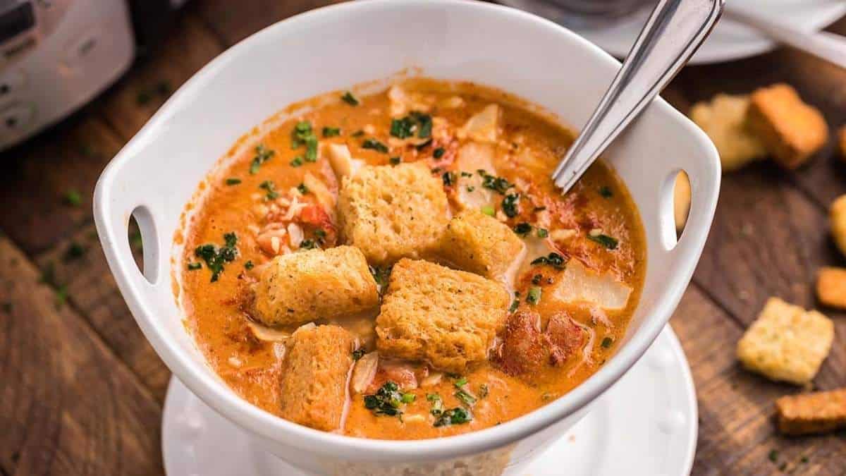A delicious soup recipe served with crispy croutons and a convenient spoon for enjoyable eating.
