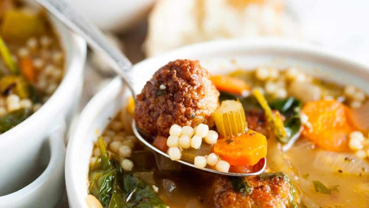 A flavorful bowl of soup with tender meatballs and colorful vegetables.