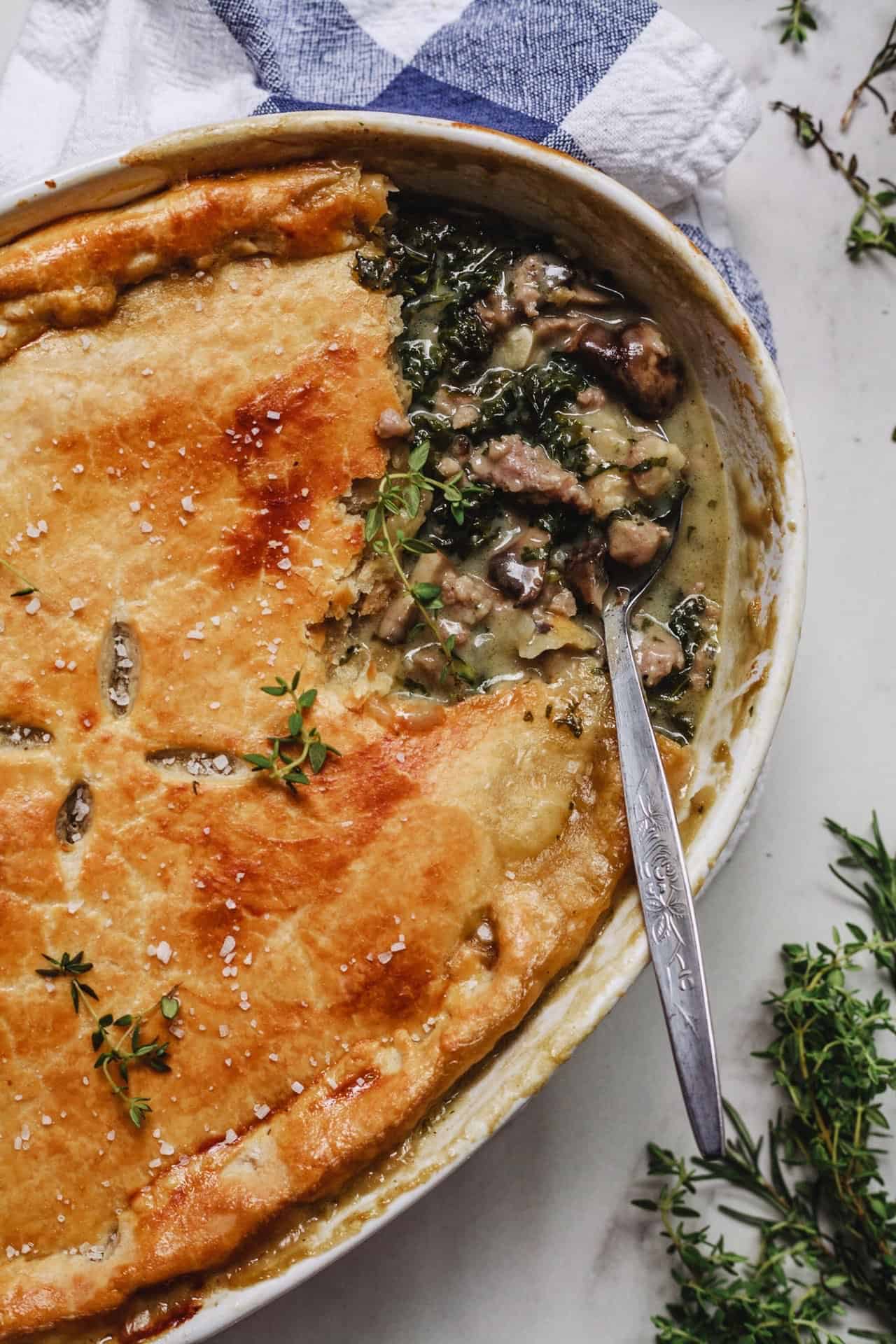 A savory mushroom and spinach pie garnished with a spoon.