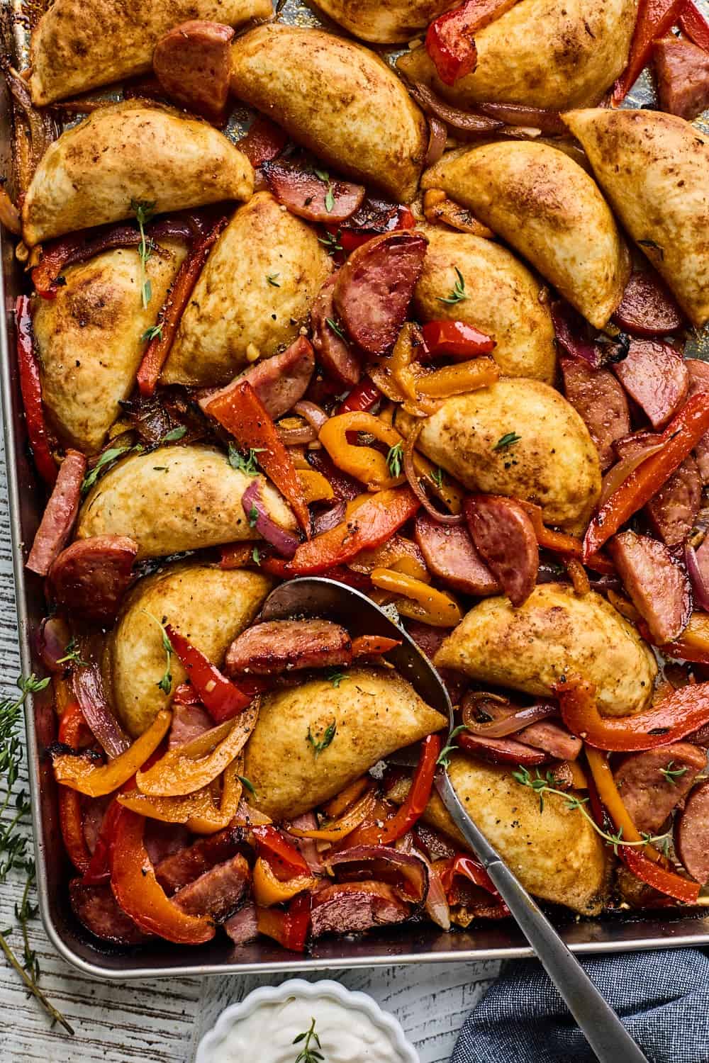 Delicious stuffed peppers and sausages baked on a sheet.
