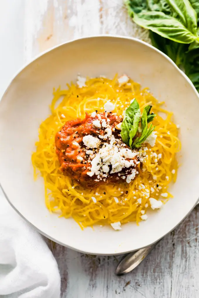 A bowl of spaghetti with tomato sauce and parmesan cheese.