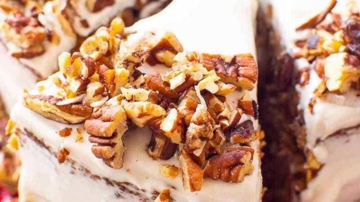 A slice of cake with pecans on top.