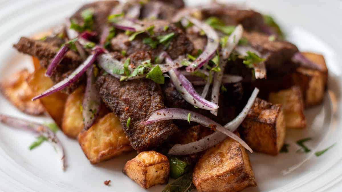 A plate with steak and potatoes on it.