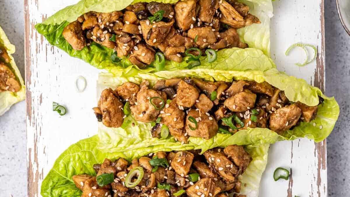 Asian chicken lettuce wraps on a cutting board.