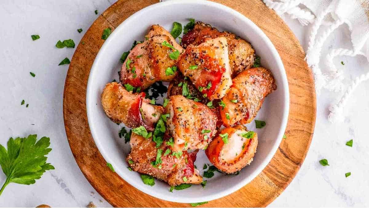 Chicken breasts in a white bowl with parsley and parmesan.
