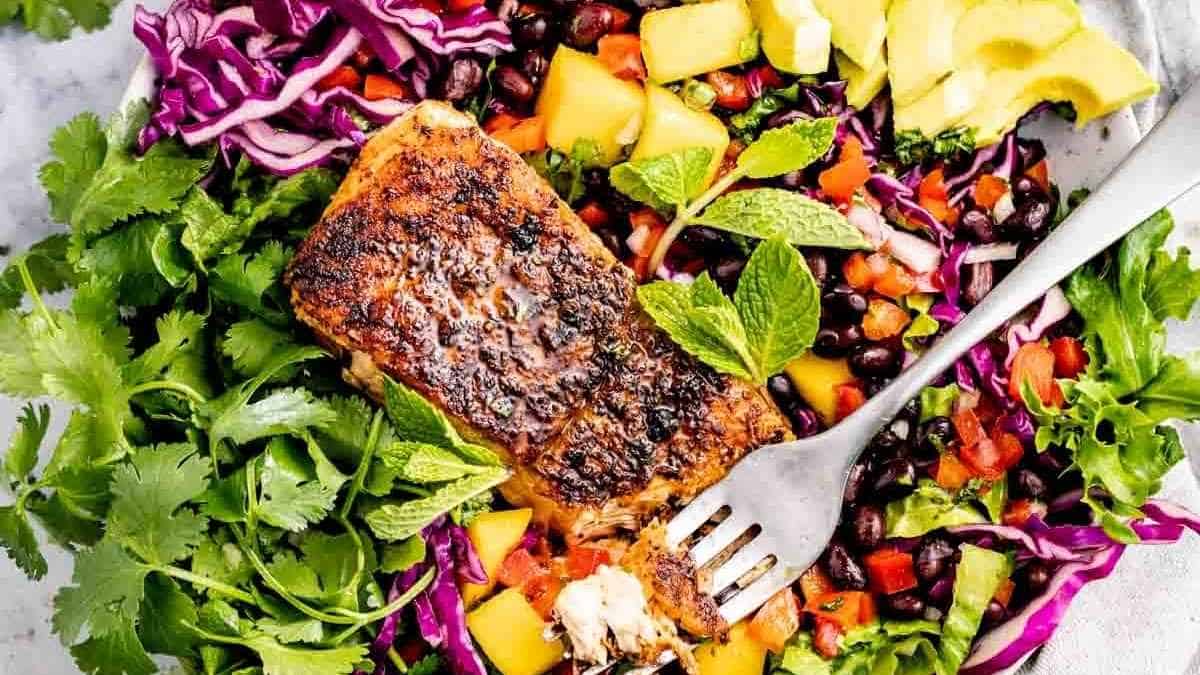 A plate of grilled salmon salad with a fork.