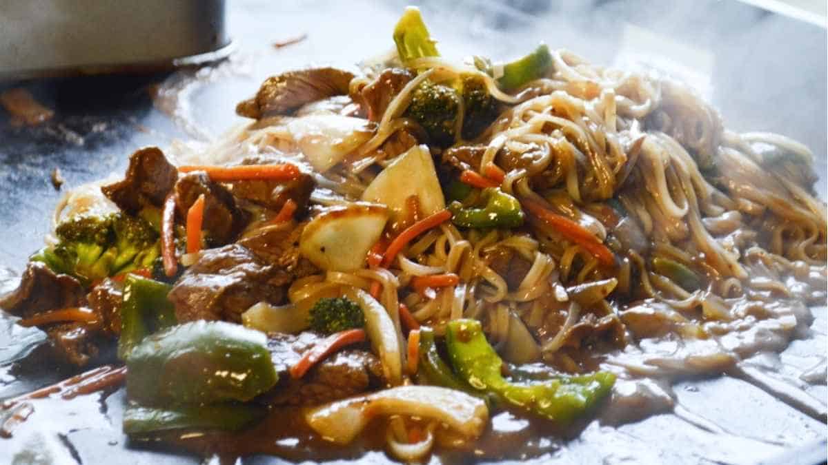 Chinese food in a wok with vegetables and meat.