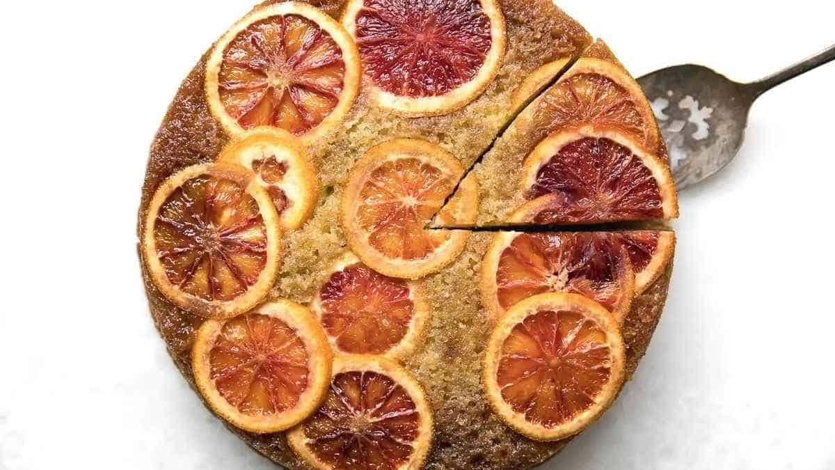 A blood orange cake with a slice taken out.