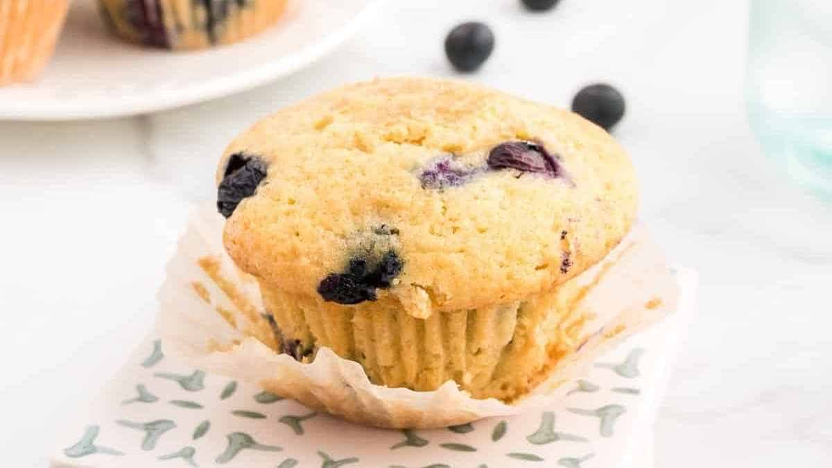 Blueberry muffins on a napkin with blueberries.