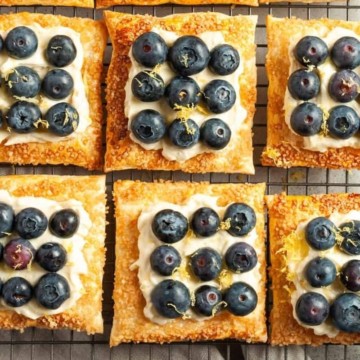 Blueberry and lemon tarts on a cooling rack.