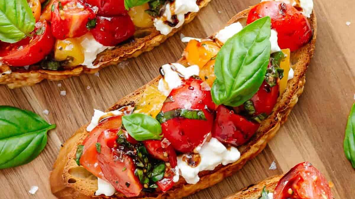 Sliced bread with tomatoes and basil on it.