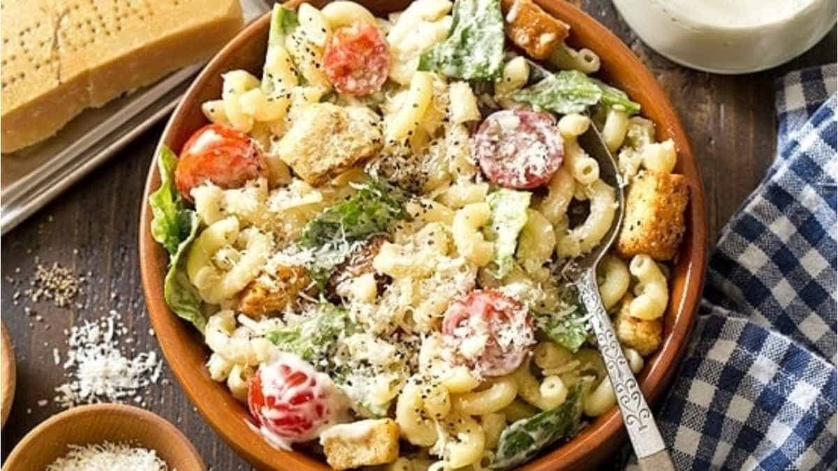 Pasta salad with croutons and tomatoes in a bowl.