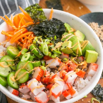 A vibrant Asian noodle bowl filled with fresh vegetables and topped with imitation crab.