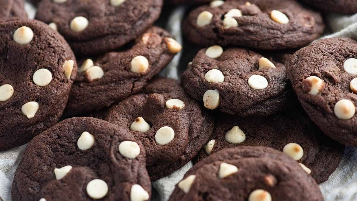 A pile of chocolate cookies with white chocolate chips.