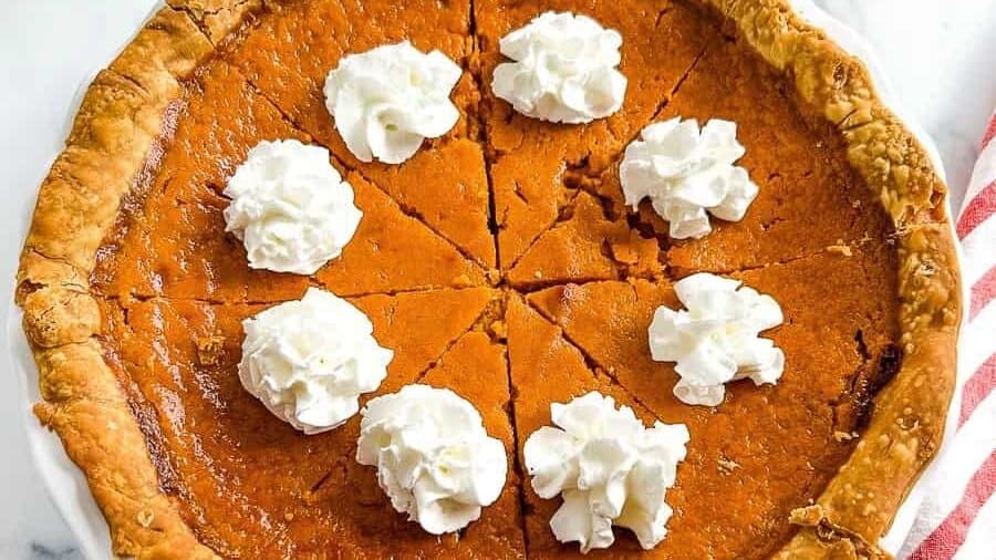 A pumpkin pie with whipped cream on top.