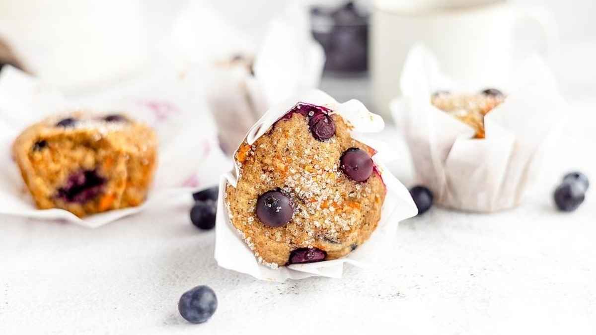 Blueberry muffins on a white background with a cup of coffee.